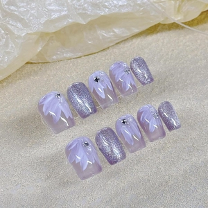 Faux ongles violets faits main avec motifs de pétales peints et strass brillants