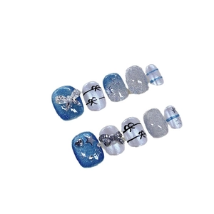 Blue glitter press-on nails with silver cat-eye effect and 3D bow star decorations