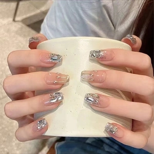 Detail of handmade press-on nails with silver glitter, 3D fluid metal art and rhinestones