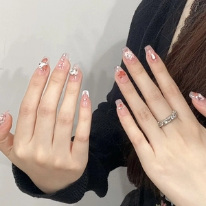 Handmade press-on nails featuring 3D heart charms, rhinestones, and strawberry nail art