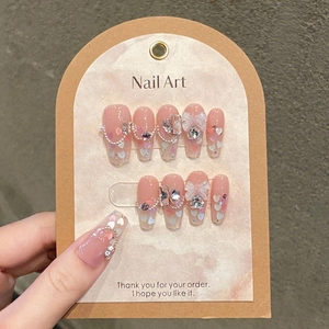 Handmade pink cat-eye press-on nails with butterfly bows and heart rhinestones