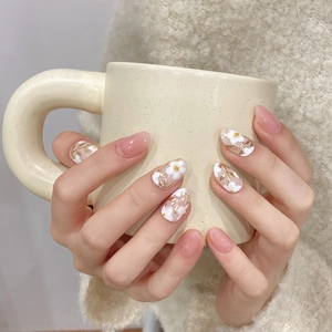 Pink jelly press-on nails with white 3D flower art and gold accents on almond shape