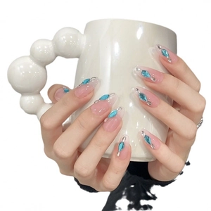 Pink jelly long almond press-on nails with blue teardrop gems and subtle rhinestone accents