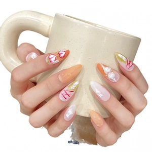 Handmade almond press-on nails with 3D white roses and pink hearts on orange gradient
