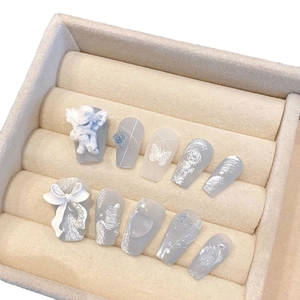Handmade press-on nails featuring 3D angel sculpture, white bow and pearl embellishments