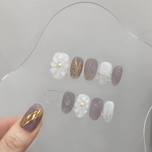 Handmade press-on nails with purple marble design, 3D floral accents, and pearls