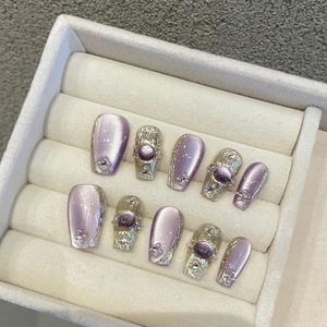 Handmade purple cat eye press-on nails with silver wire, pearls, and rhinestones in a box
