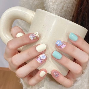 Faux ongles menthe et crème avec motifs floraux sur une forme carrée arrondie
