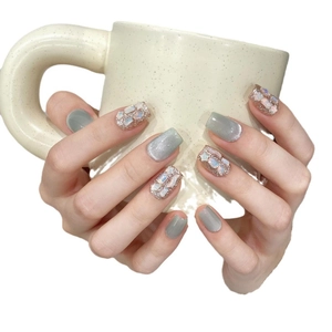 Handmade cat eye press-on nails in emerald green with glitter and shell fragments