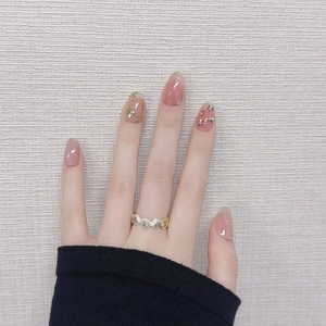 Pink gradient press-on nails with golden floral relief and wavy decorative ring