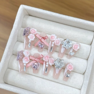 Unghie finte rosa con rose 3D, fiocchi di seta, cristalli e perle in scatola bianca