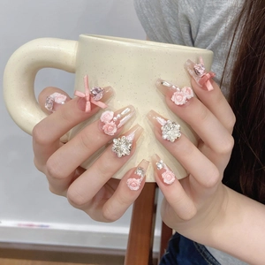 Unghie finte sfumate rosa con rose in resina e fiocchi di seta su tazza