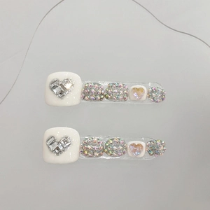 Handmade white press-on toenails featuring silver hearts and iridescent rhinestones