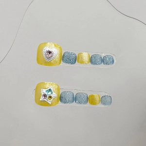 Handmade press-on toenails featuring yellow and blue glitter with heart and gem accents