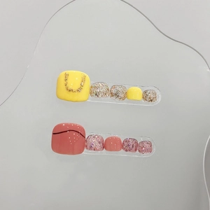 Handmade press-on toenails in bright yellow and coral pink with glitter accents