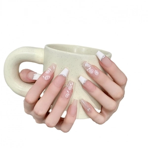 Handgemaakte roze kunstnagels met witte bloempatronen en subtiele parels
