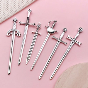 Detail of 6 vintage silver sword pendants for DIY jewelry with intricate hilt textures