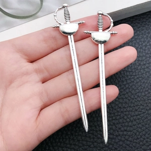 Detailed view of alloy sword pendants with silver plating and textured hilt detail