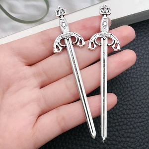 Detail of vintage silver alloy sword charms with Gladiator engraving for DIY jewelry