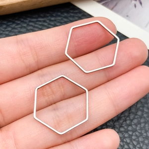 Close-up of geometric hexagonal silver stainless steel pendants for DIY jewelry making