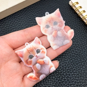 Detalle macro de colgantes de gato acrílicos mostrando material y calidad de impresión