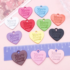 Détail de 12 pendentifs en forme de cœur colorés avec texte en relief et règle
