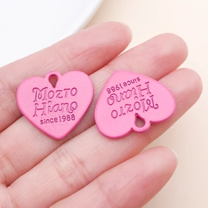 Gros plan de pendentifs en cœur rose avec texte embossé pour la création de bijoux DIY
