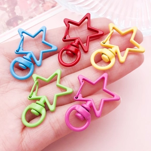 Hand holding colorful star-shaped zinc alloy keychains with 360-degree swivel rings