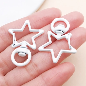Close-up of white star-shaped spray-painted zinc alloy swivel lobster clasps for bags