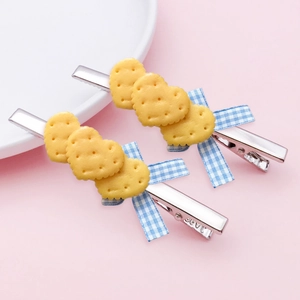 Detail view of heart-shaped biscuit hair clips with blue plaid ribbon bows on duckbill clips