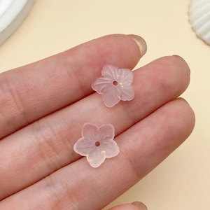 Vista macro de cuentas de flor de cerezo rosa mate con pan de oro para joyería artesanal