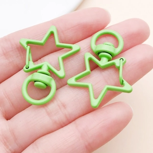 Close-up of matte light green star-shaped lobster clasps with rotating rings for DIY