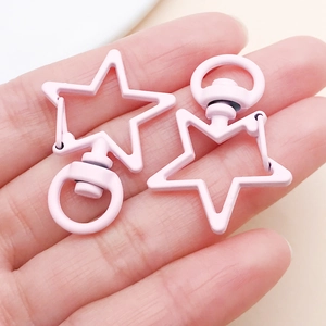 Close-up of pink star-shaped alloy keychain with 360-degree swivel clasp and painted finish