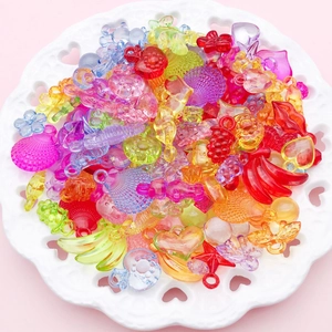 Close-up of colorful heart and star shaped transparent acrylic beads in a ceramic tray