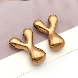 Nahaufnahme goldener unregelmäßiger Metallanhänger mit spiegelglatter Oberfläche für DIY-Schmuck