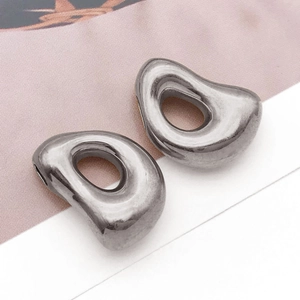 Makroaufnahme silberner hohler Metallanhänger in Tropfenform für DIY-Schmuckdesign