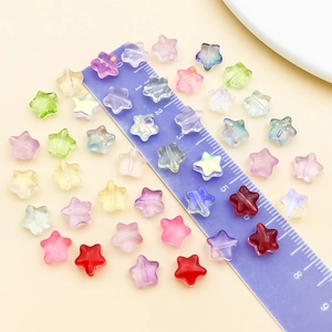 Macro shot of colorful star-shaped beads with a ruler showing the 10mm diameter detail