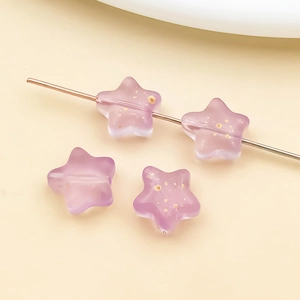 Macro detail of purple star-shaped glass beads with gold foil for DIY jewelry making