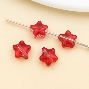 Close-up of red star-shaped glass beads with center holes for DIY jewelry making