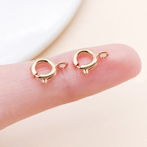 Macro shot of 6mm small rose gold spring ring clasps on fingertip for jewelry DIY