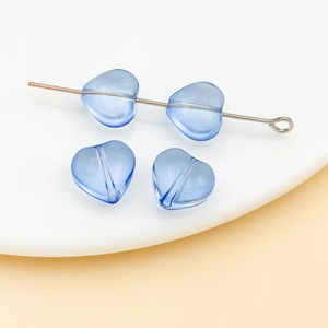 Macro detail of 10mm light blue heart-shaped glass beads for jewelry making