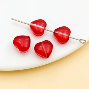 Macro view of 10mm transparent red glass heart beads with vertical holes for jewelry