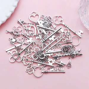 Close-up of vintage silver alloy key pendants with heart and crown designs for DIY jewelry