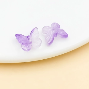 Detailed macro view of purple gradient butterfly glass beads for handmade jewelry