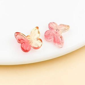Macro shot of gradient butterfly glass charms with gold glitter for DIY jewelry