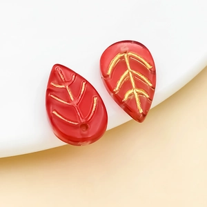 Detail of red leaf-shaped glass beads with gold veins for DIY jewelry making
