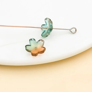 Détail macro de perles cerisier en verre dégradé sur tige pour création de bijoux DIY