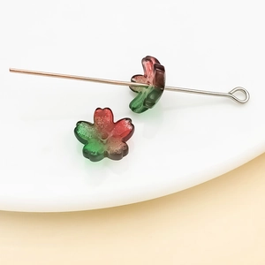 Vue macro de perles fleurs de cerisier en verre dégradé sur tiges en acier pour bijoux DIY