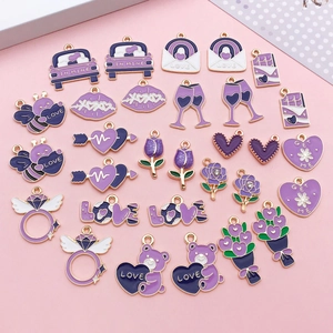 Detailed flat lay of purple enamel charms including car, heart, and bee for DIY jewelry
