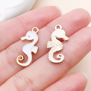 Détail de pendentifs hippocampe en émail blanc et finition dorée pour bijoux